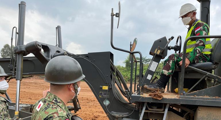 یک مربی نظامی ژاپنی به سربازی از سومین گردان مهندسی رزمی ارتش اندونزی کمک می کند تا مهارت های خود را در رانندگی گریدرهای جاده ای - تجهیزاتی که برای خدمت در ماموریت حفظ صلح MINUSCA در جمهوری آفریقای مرکزی به آن نیاز دارد - تسلط پیدا کند.