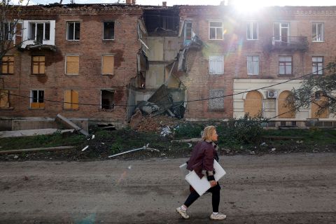 زنی از مقابل ساختمانی که در اثر حمله موشکی در منطقه شرقی دونباس در باخموت اوکراین در روز 1 نوامبر تخریب شده بود عبور می کند.