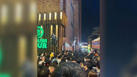 مردی در حال بالا رفتن از ساختمانی برای فرار از جمعیت در Itaewon، سئول، در 29 اکتبر دیده می شود. 