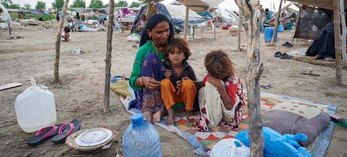 خانواده ای پس از آسیب دیدن خانه شان در سیل ویرانگر، زیر یک پناهگاه موقت در استان سند پاکستان نشسته اند.