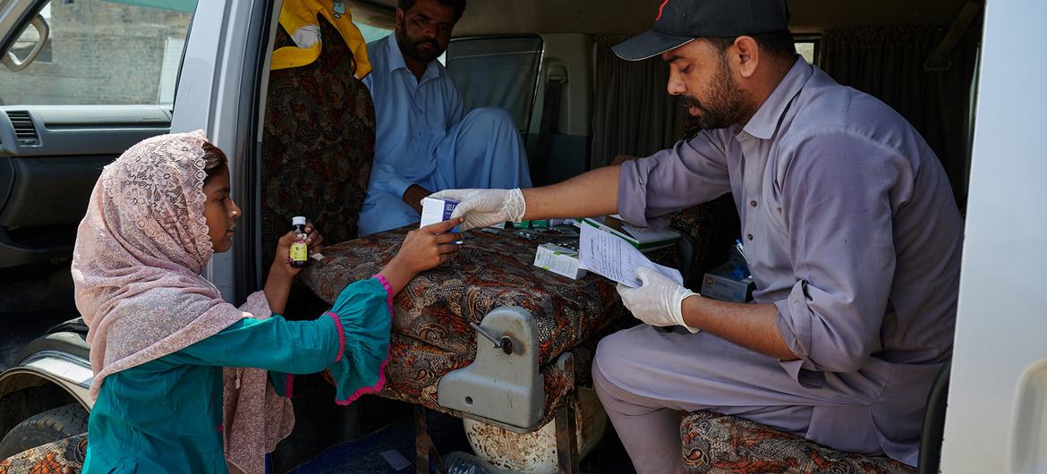 یک دختر جوان داروی خود را از یک واحد صحی سیار که برای سیل زدگان در منطقه شانگر پاکستان راه اندازی شده است تهیه می کند.