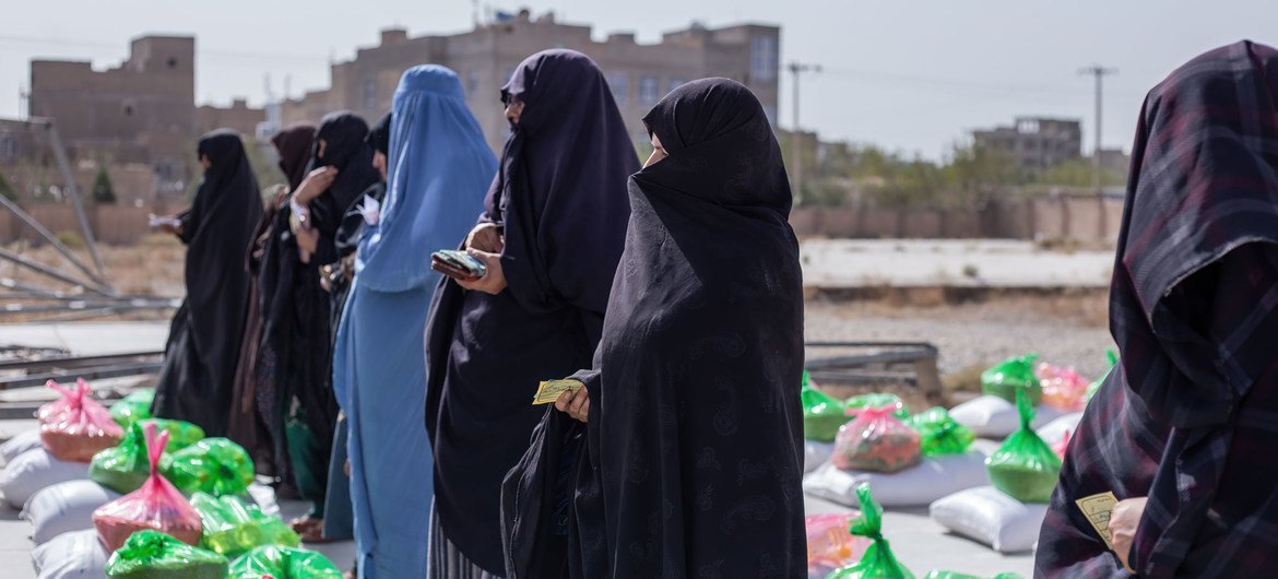 زنان در یک سایت توزیع غذا در هرات افغانستان جیره غذایی دریافت می کنند.