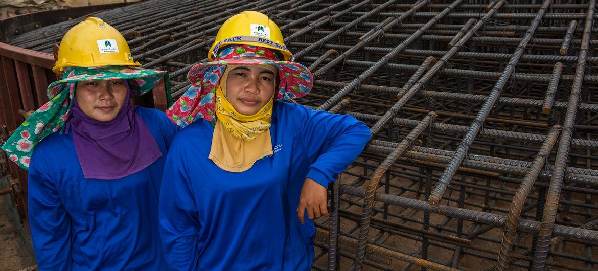 یک کارگر ساختمانی به ساخت پایه یک مزرعه بادی در تایلند کمک می کند.