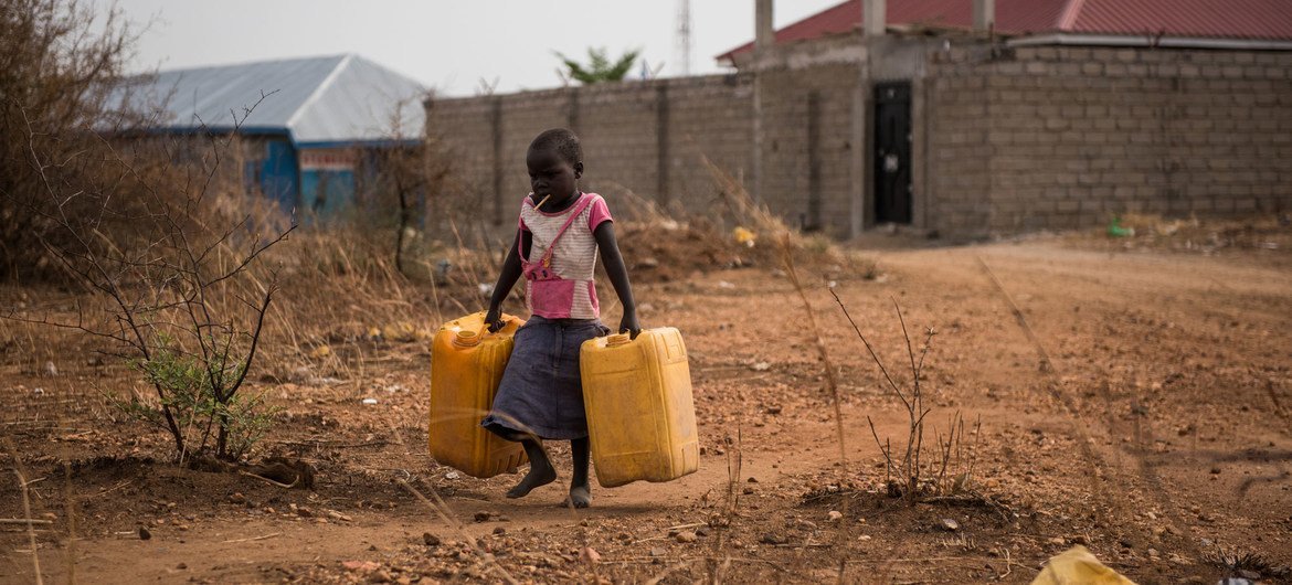 کودکی کاسه های خالی را حمل می کند تا آب را از یک شیر آب در نزدیکی پر کند که آب تصفیه نشده رودخانه نیل در جوبا، سودان جنوبی را تامین می کند.